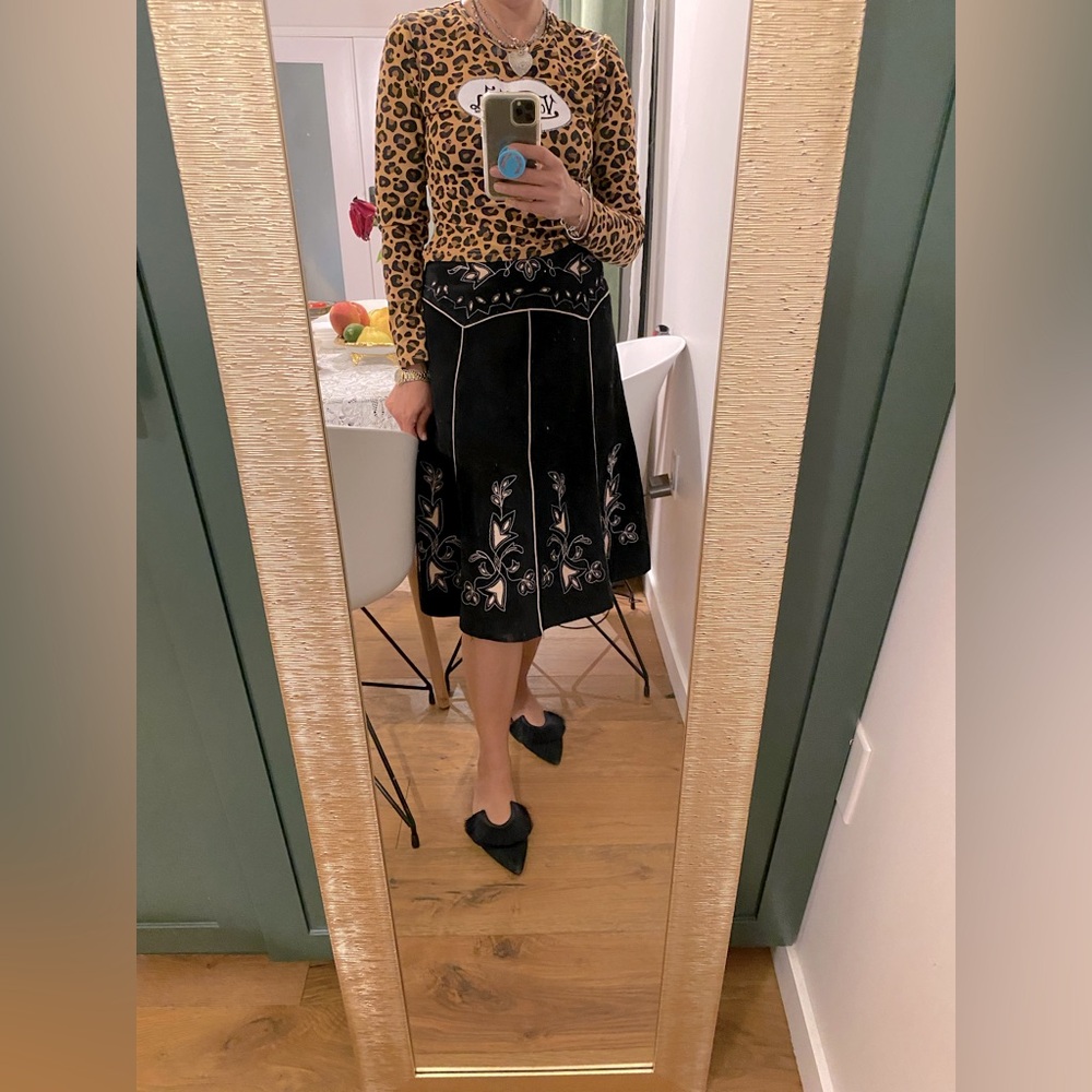 For Joseph The image displays a black suede skirt with intricate light-colored .